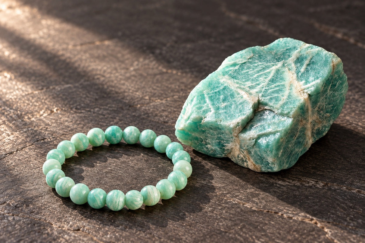 Amazonite bracelet beside a raw amazonite stone on warm slate