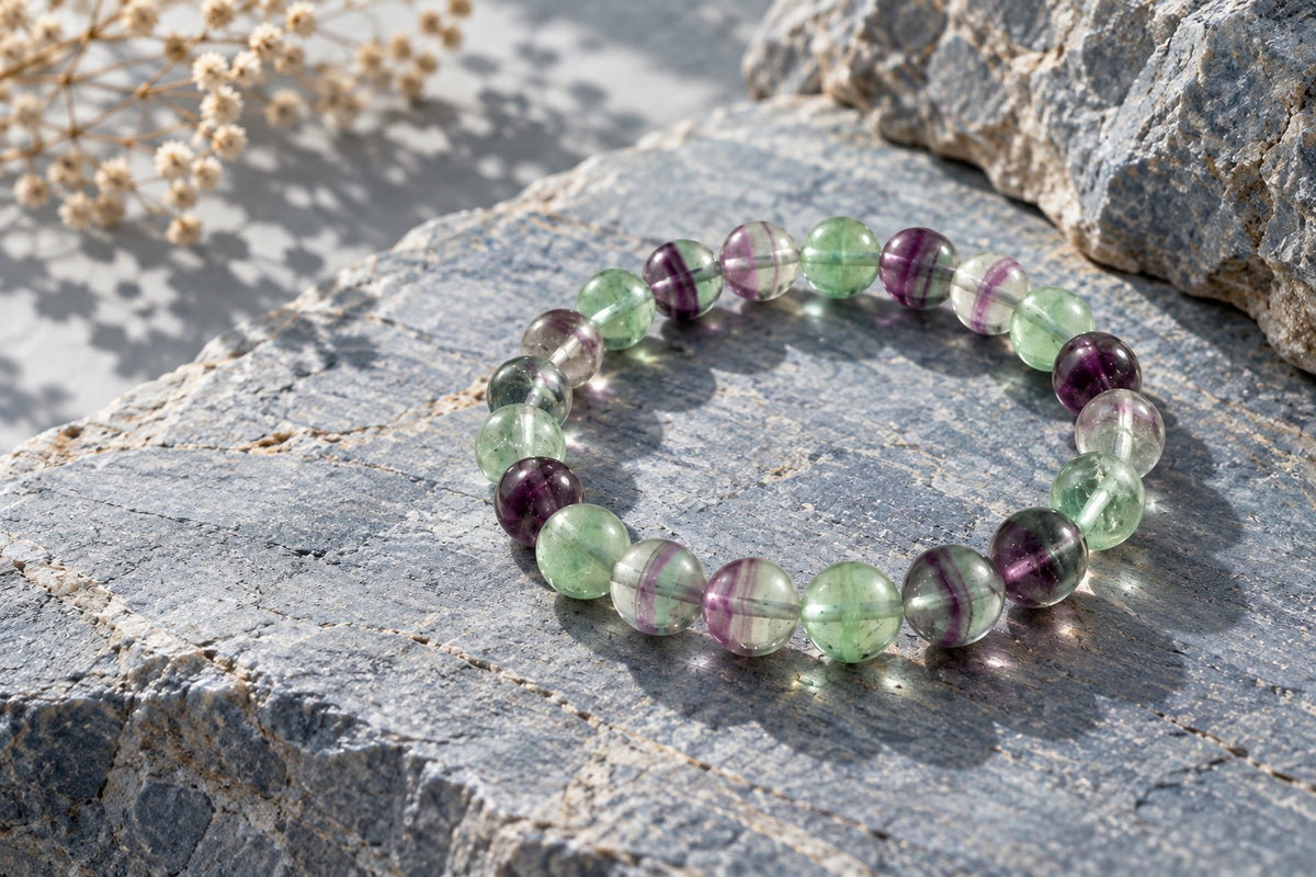 Fluorite and amethyst bead bracelet on grey stone for Aquarius