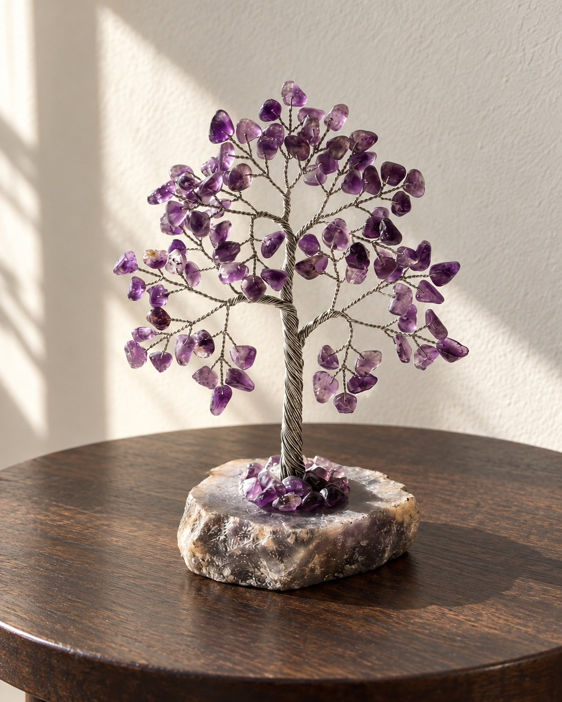 Amethyst crystal tree on a dark wooden table in soft light