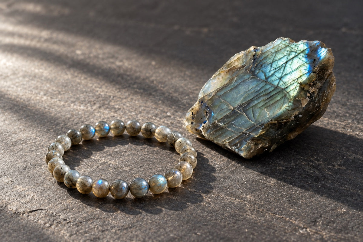 Labradorite bracelet beside a raw labradorite stone showing blue flash