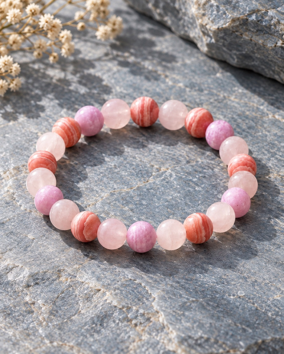 Rose quartz and rhodochrosite bead bracelet on grey stone for Libra
