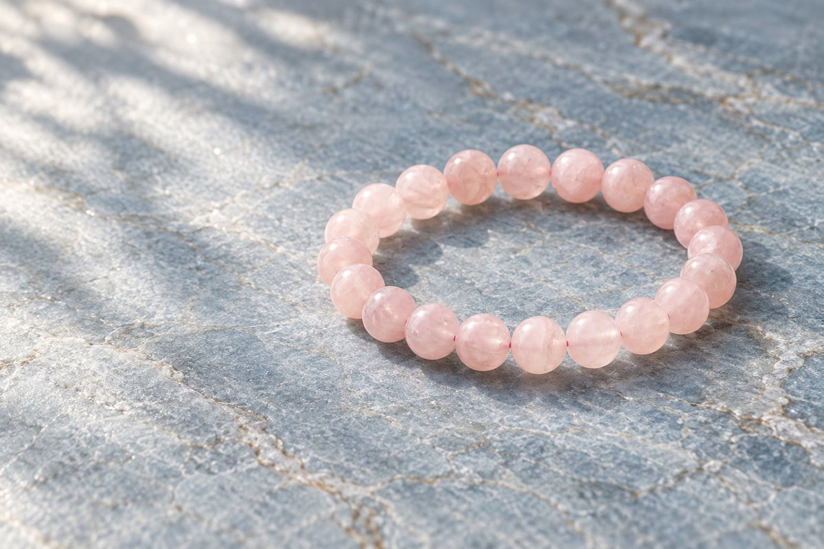 Rose quartz bead bracelet on pale grey stone
