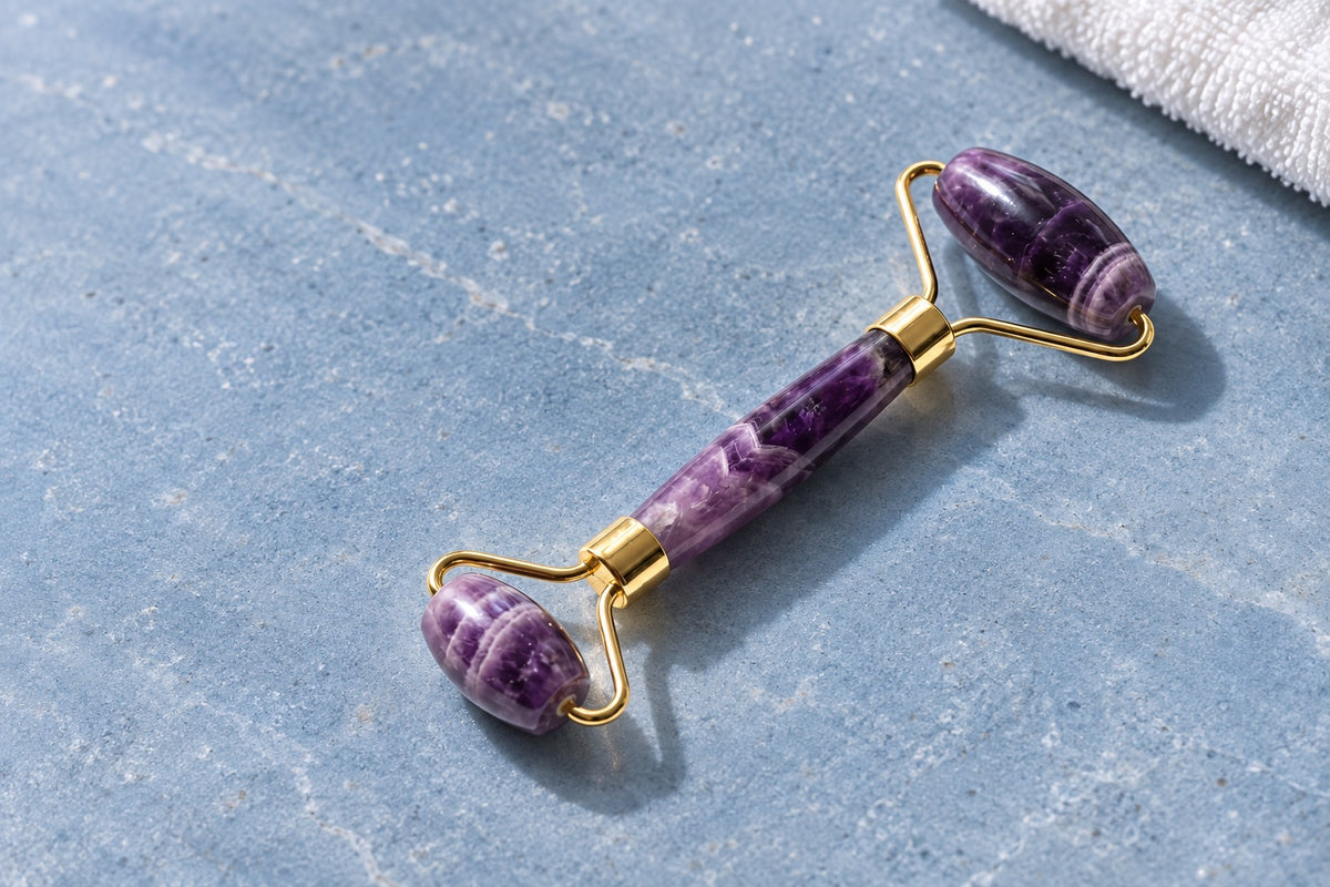 Amethyst face roller with gold fittings on pale blue stone